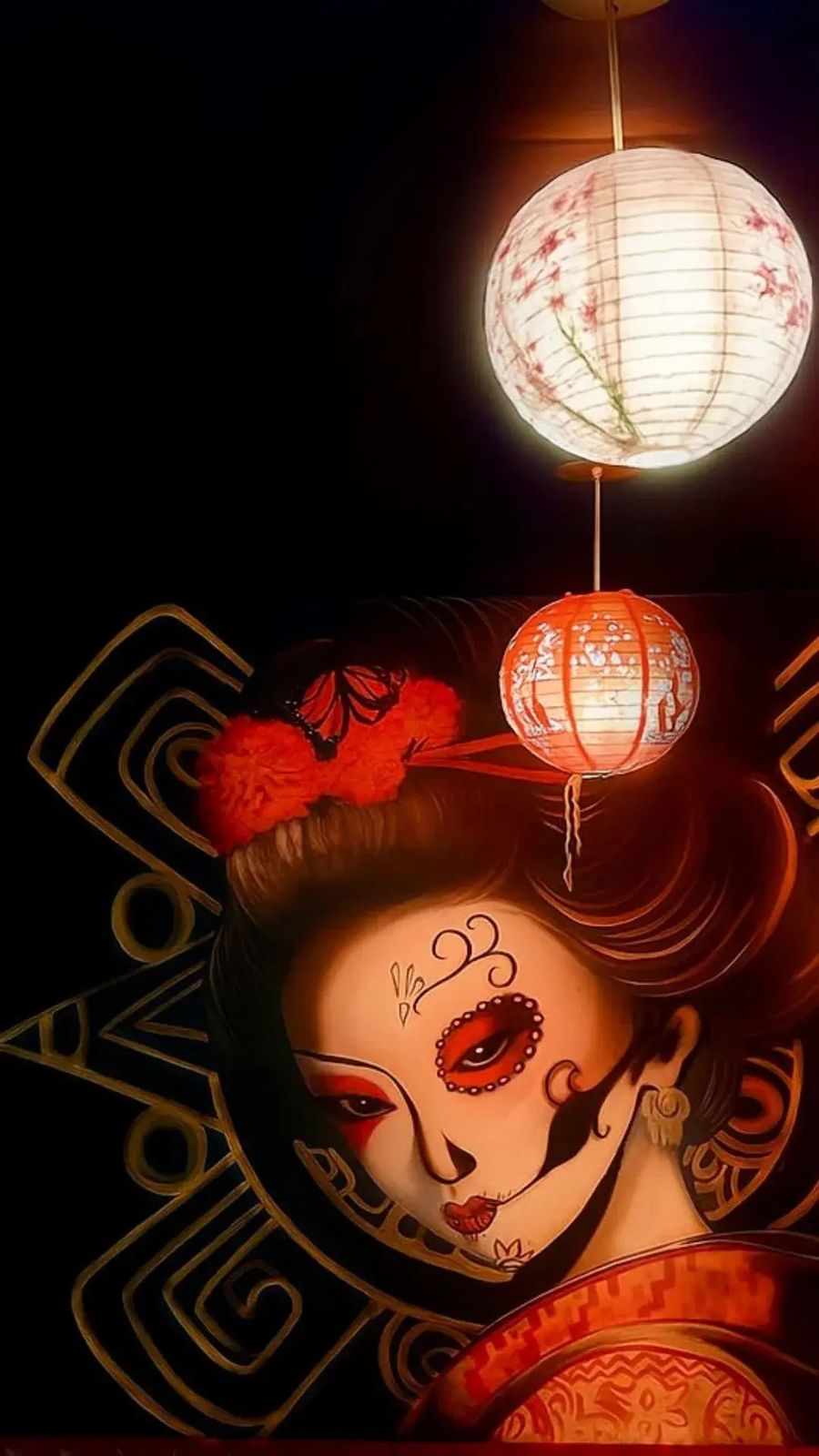 The geisha mural inside Chinaloa, painted with Día de los Muertos face paint under paper lanterns